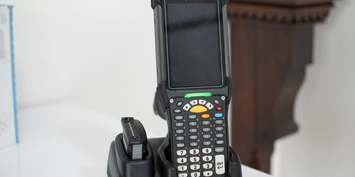Handheld barcode scanner docked at a charging station, representing the Inventory Sync Pipeline project